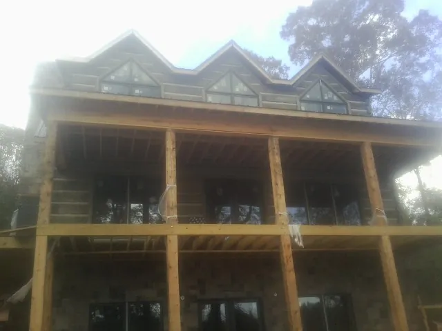 Dormers and porch framing on a large log home under construction — Roof Coating work by our crew in Garden Valley