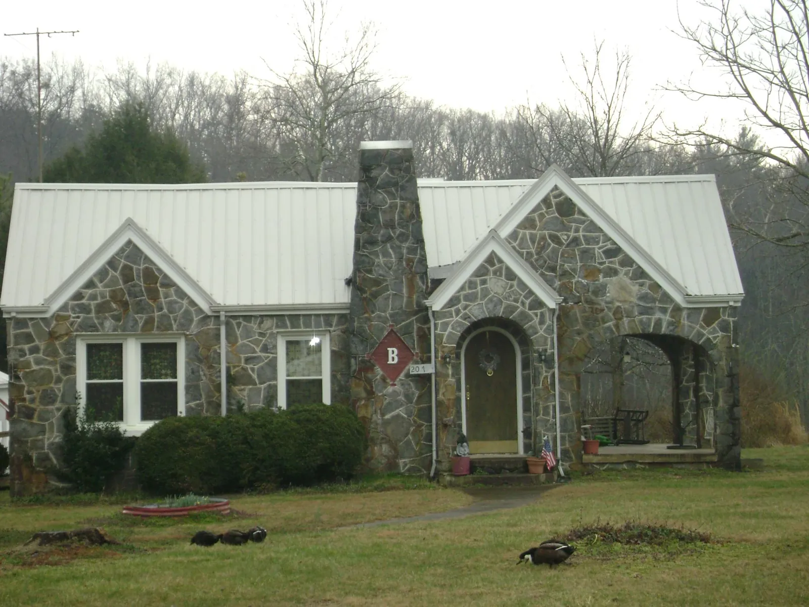 White metal roof on a stone cottage with steep gables in Garden Valley