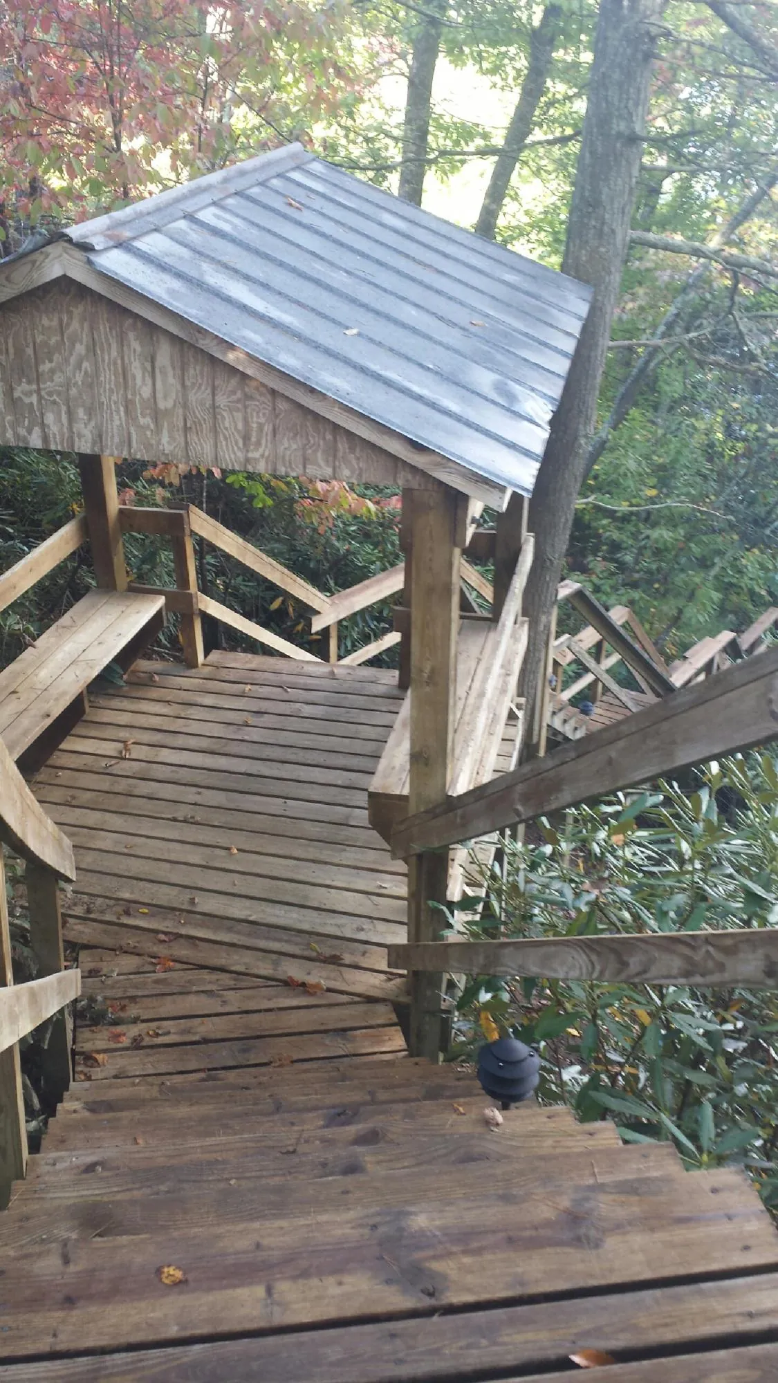 Metal roofed shelter over wooden steps on a wooded walkway — Skylight Repair & Installation work by our crew in Garden Valley