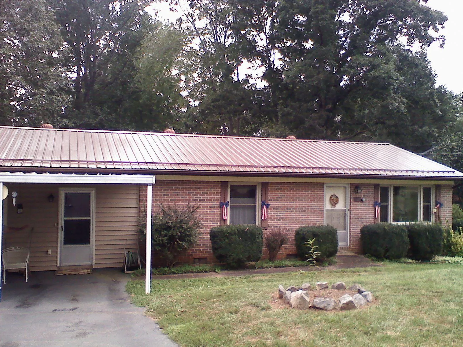 Bronze metal roof and carport on a brick ranch home — Roof Repair work by our crew in Garden Valley